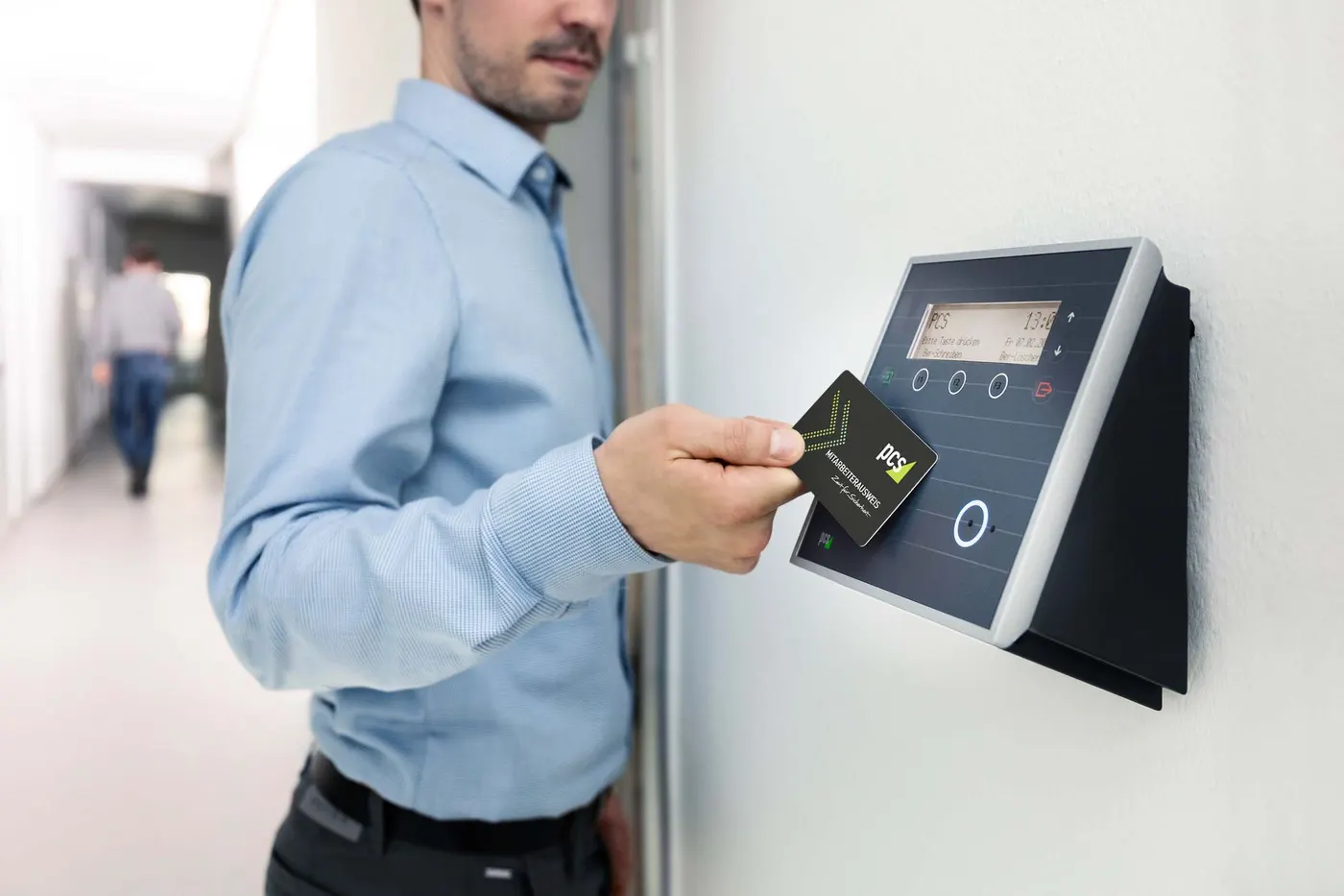 Employee presenting an RFID card to a wall-mounted card reader terminal