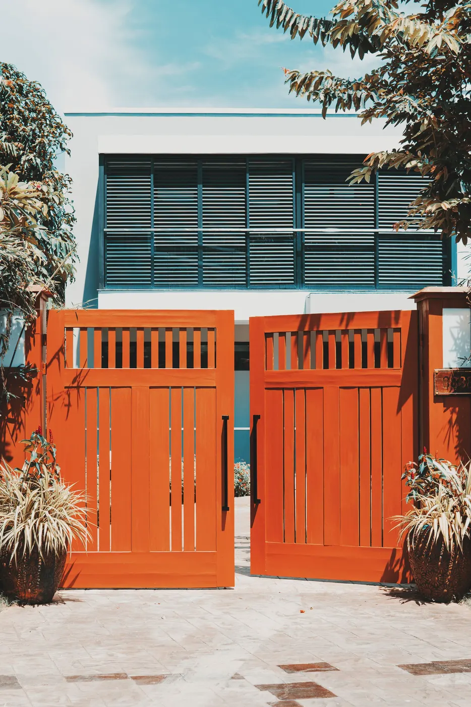 Wooden driveway gates in front of a modern home