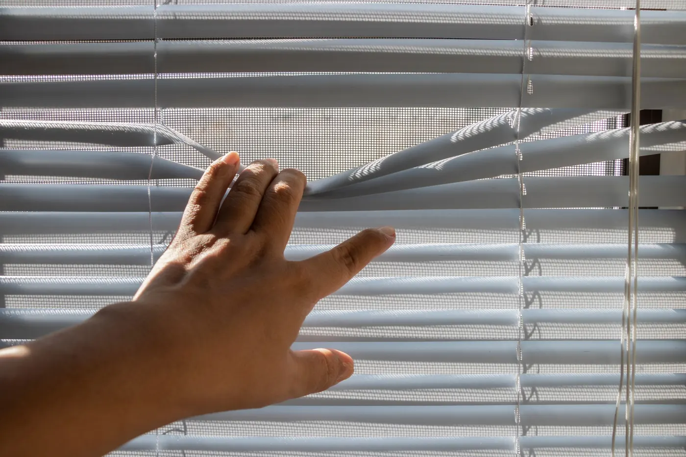 Hand adjusting horizontal window blinds